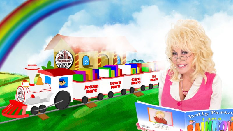 Dolly Parton beside a train of books.